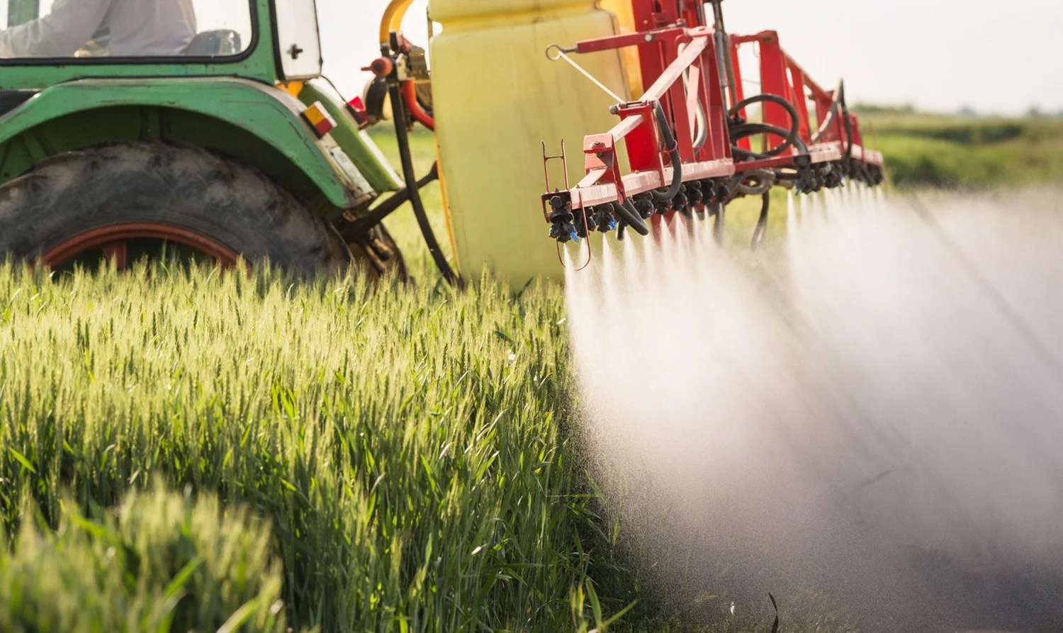 A sprayer applying a foliar feed across a field